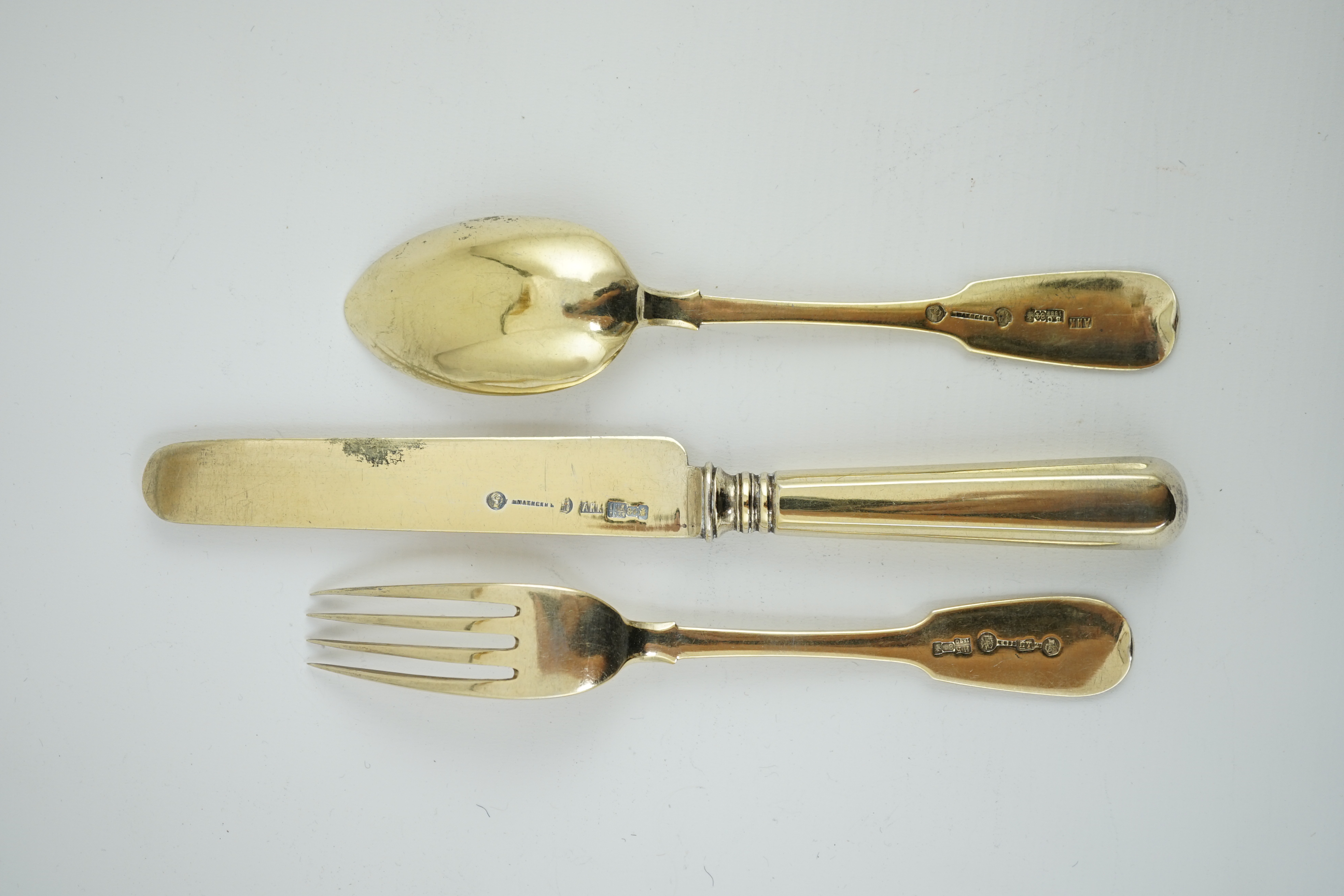 A set of six late 19th century Russian 84 zolotnik silver gilt fiddle pattern dessert spoons, a set of six matching dessert knives and dessert forks, master Alexander Matisyev and A. Krilov, unknown assay master, Moscow,